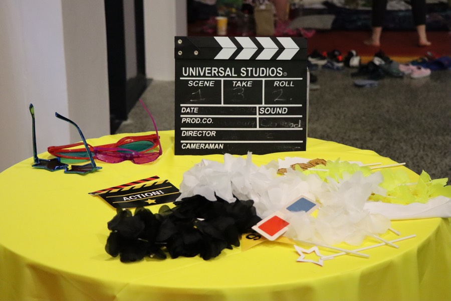 A table of photo props including a clapperboard and colourful glasses